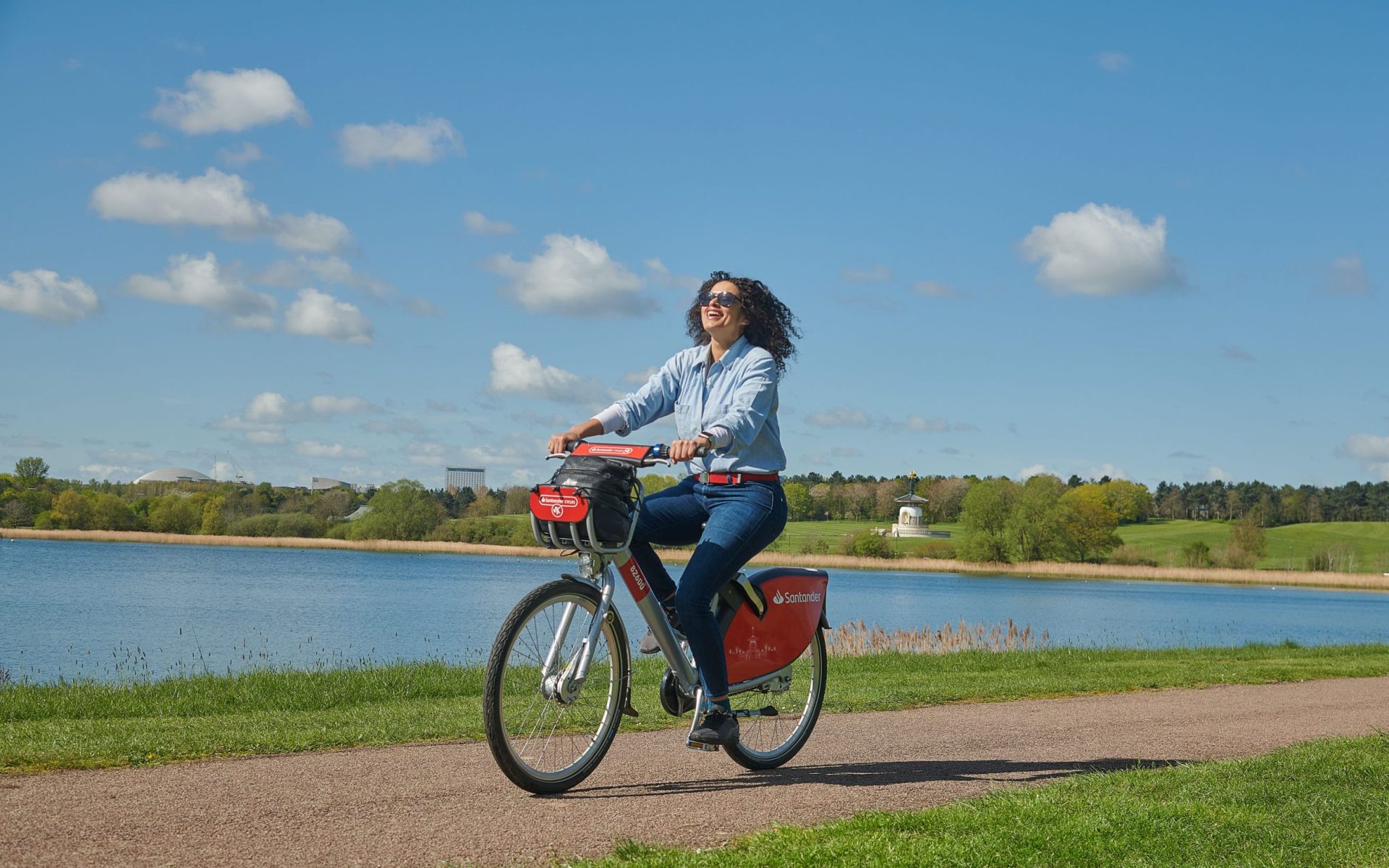 image-nextbike-by-tier-milton-keynes-woman-smiling-riding-santander-cycle-bike-share-lake-bike-path